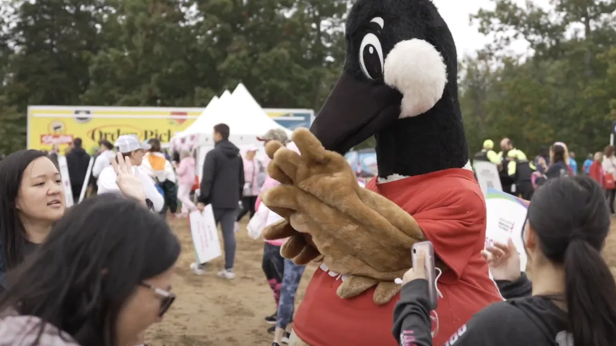 A photo of Wawa's goose mascot Wally Goose talking to people at an outdoor event.