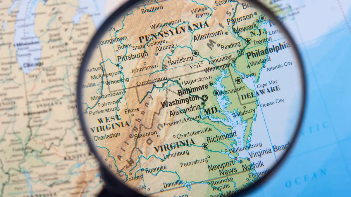 A close-up of a map shows the Mid-Atlantic area under a magnifying glass.