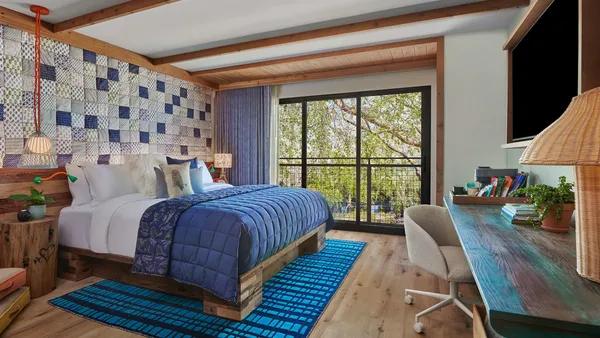 A blue bed in a hotel room.