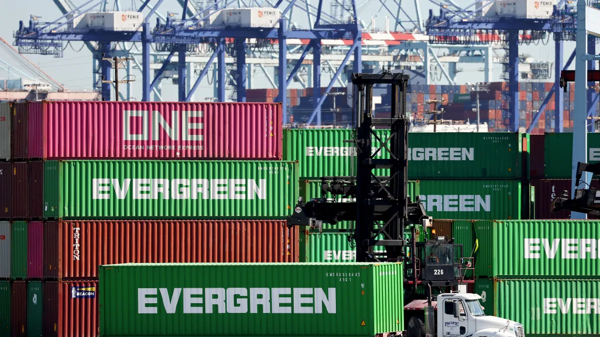 A truck drives near shipping containers stacked at the Port of Los Angeles on February 7, 2023.