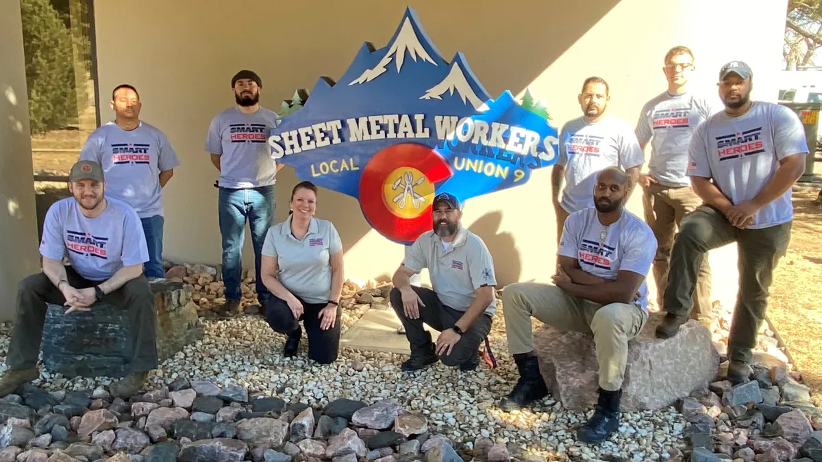 A group of people pose for a picture with matching shirts that say "Smart Heroes."