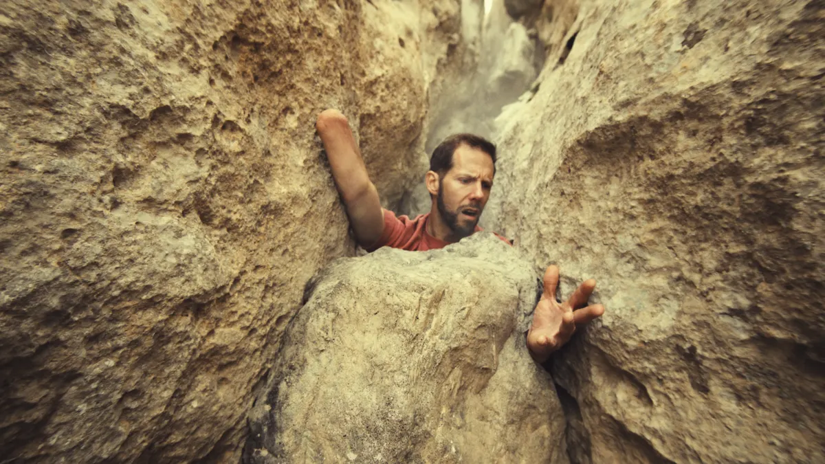 Mountaineer Aron Ralston recreates his harrowing real-life experience trapped between a boulder in an ad for Columbia Sportswear.