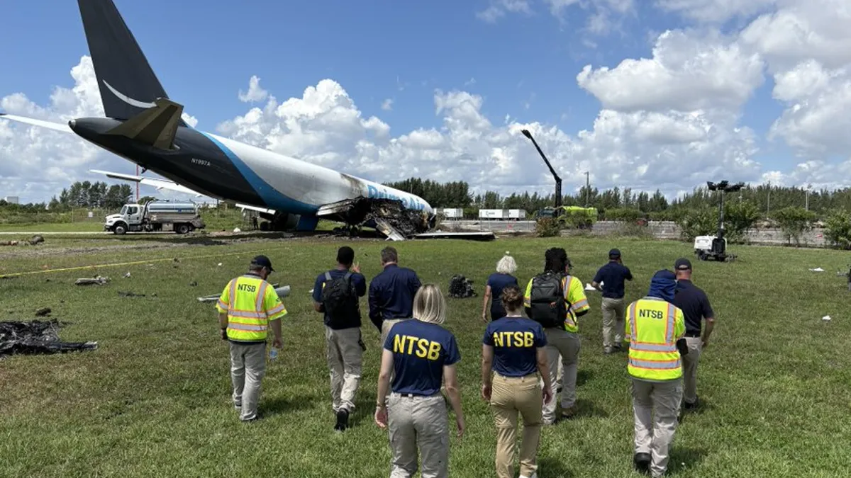 People approach the wreckage of an Amazon aircraft.
