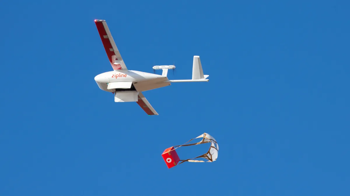 A Zipline autonomous aircraft drops off a package.