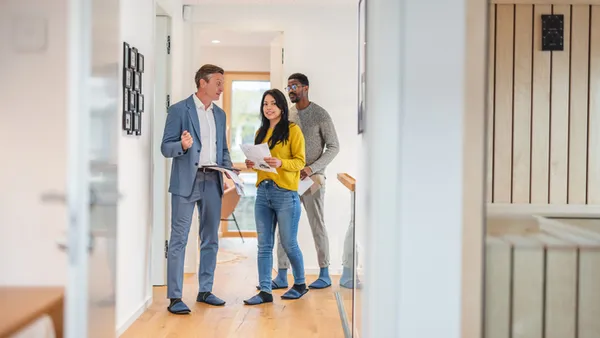 a couple is shown an apartment by a property manager