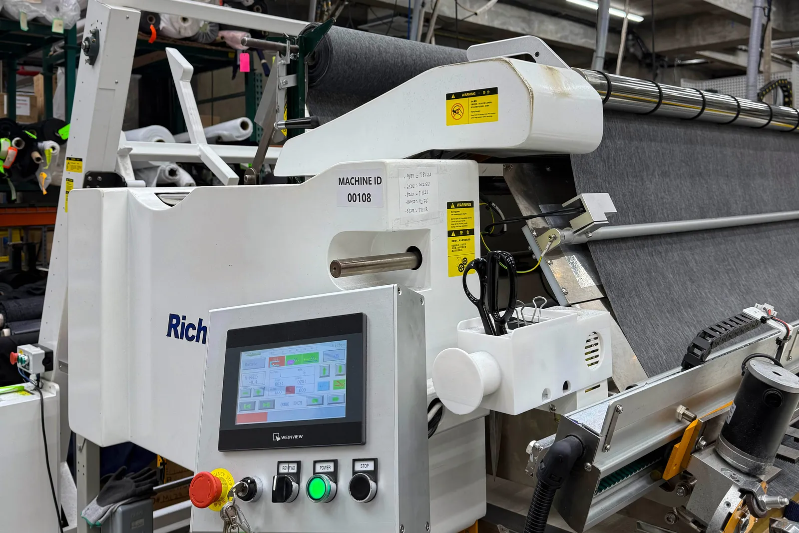 An automatic cutting tool cuts fabric in an apparel factory.