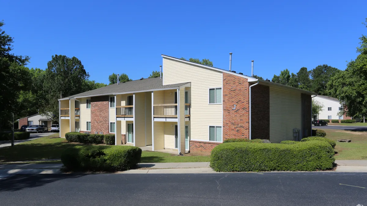 Apartment building with brick and yellow siding.