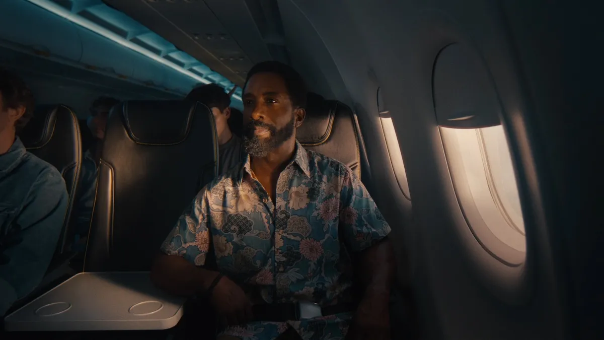 A man sits on an airline with a blocked middle seat.