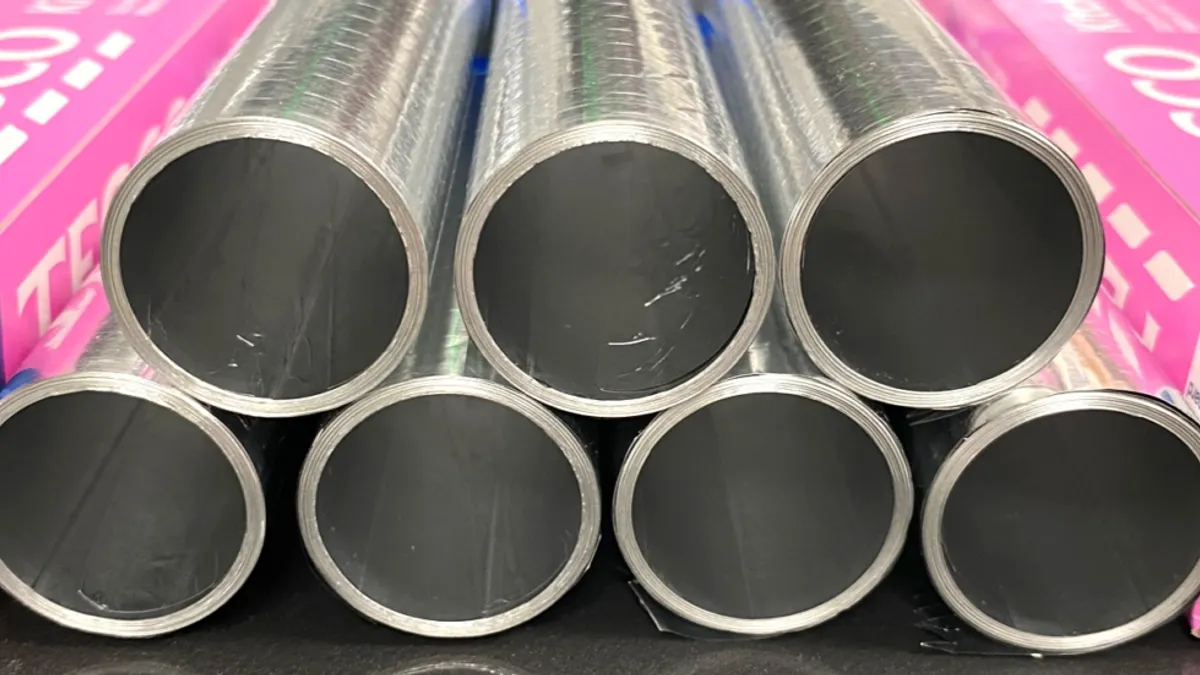 Pink boxes of Tesco aluminum foil next to a stack of foil rolls that do not contain the standard cardboard tube.