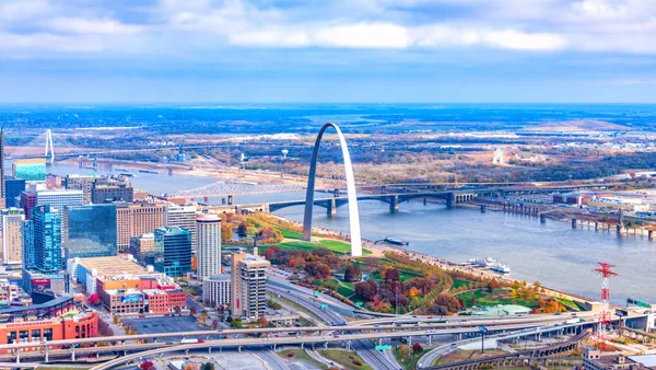 A photograph fom an altitude of about 500 feet shows an aerial view of bridges, downtown St. Louis and the Gateway Arch.