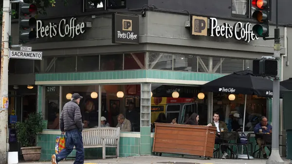 An image of a corner building with black signage that says Peet's Coffee.