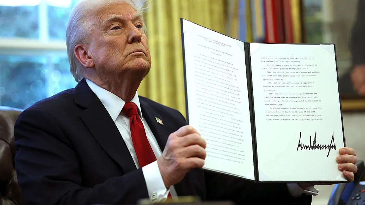 Trump holds a signed executive order in the Oval Office