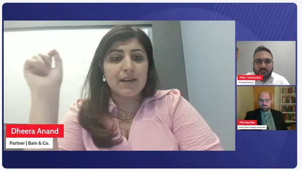 Three people are on a screen during a panel discussion, framed by banners with the corresponding name and titles.