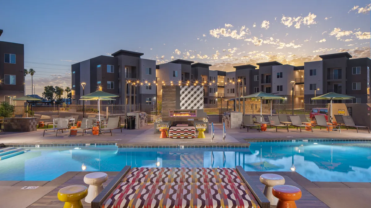 A pool in front of a mid-sized building.