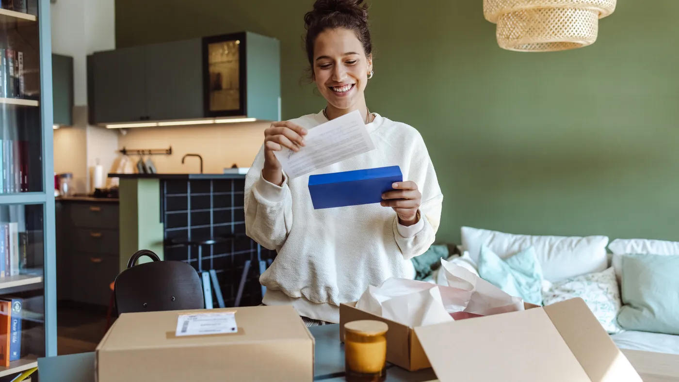 A person opens a package and reads a note.