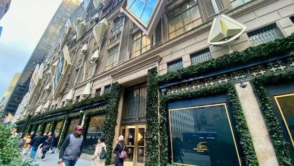People walking past a city department store building.