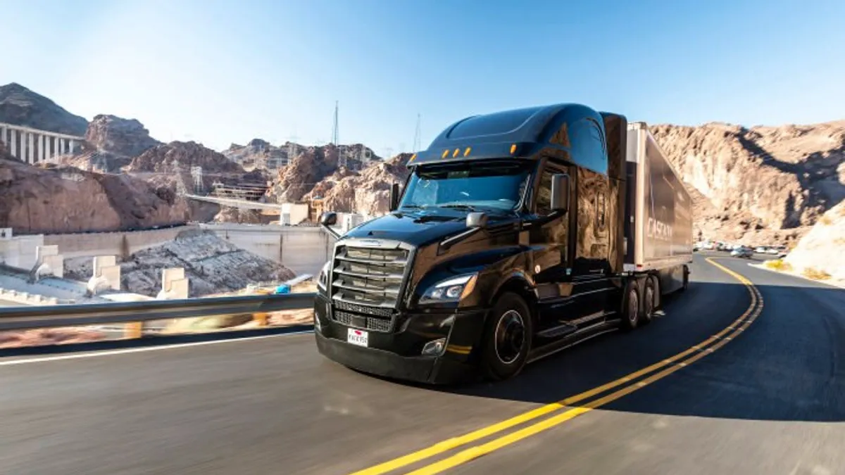 A Freightliner Cascadia truck driving on the road.