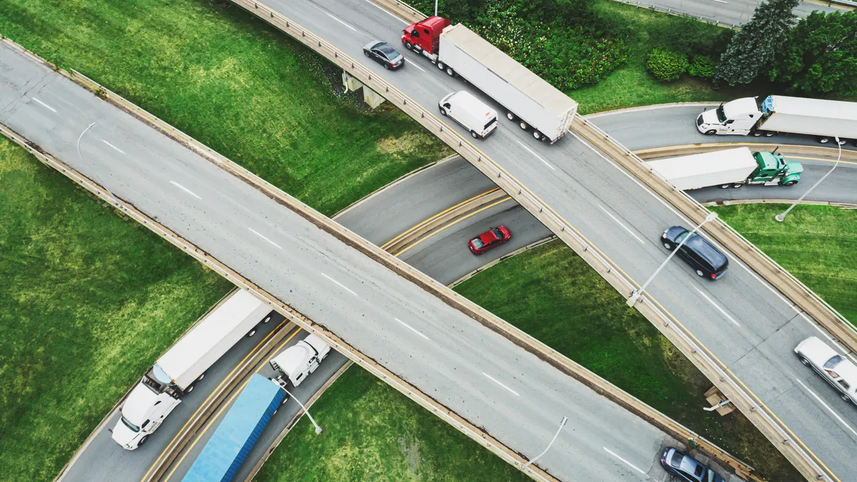 Trucks and vehicles navigate a circular interchange.