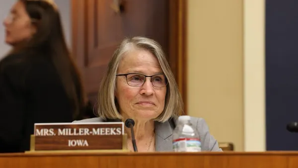 A woman sits at a podium