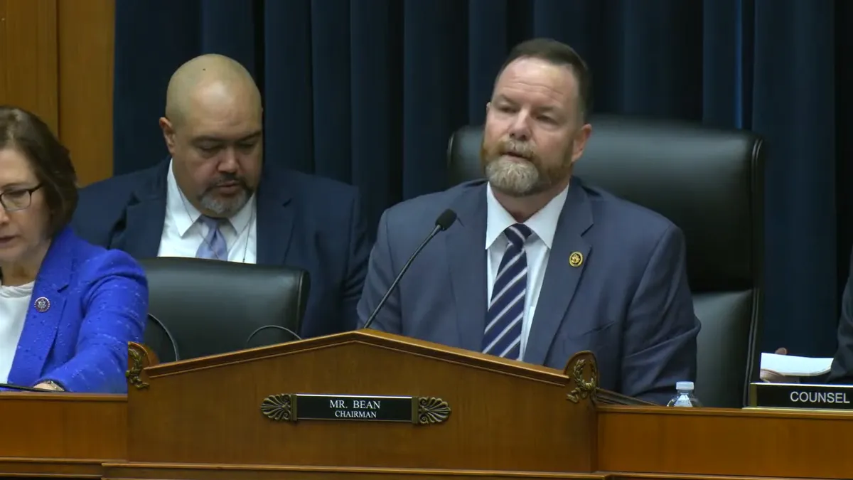 Rep. Aaron Bean speaks into a microphone in a House hearing.