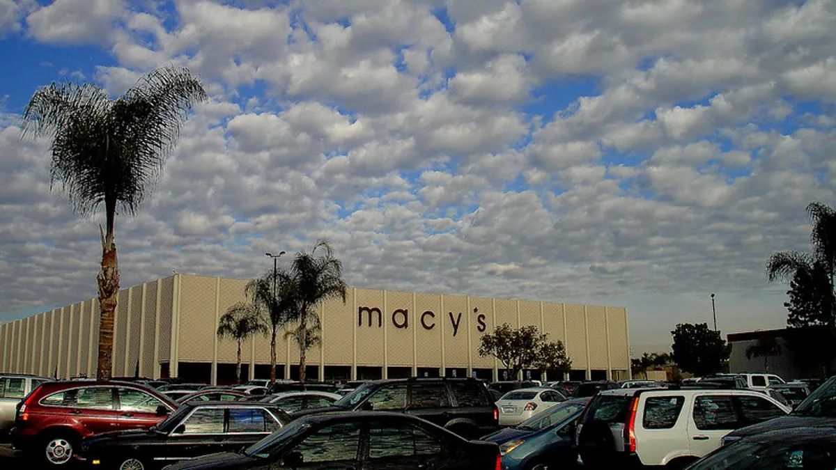A Macy's store, with parked cars in front and a palm tree on the left.