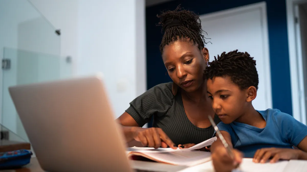 Mother helping son with homework at home