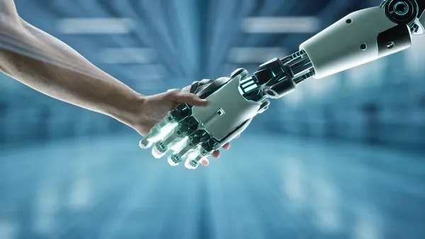 Human hand holding a robotic hand
