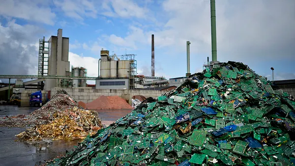 piles of electronic waste stand in separate with piles of motherboards, gold and copper at a recycling plant