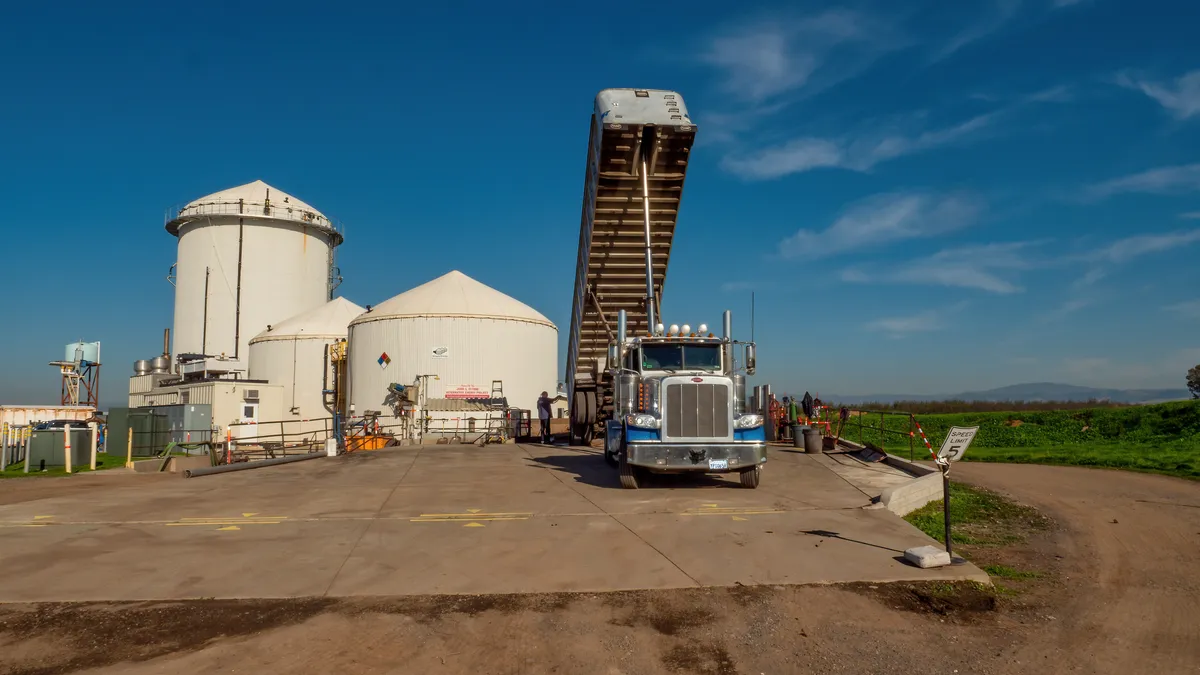 A truck dumps waste at an industrial facility.