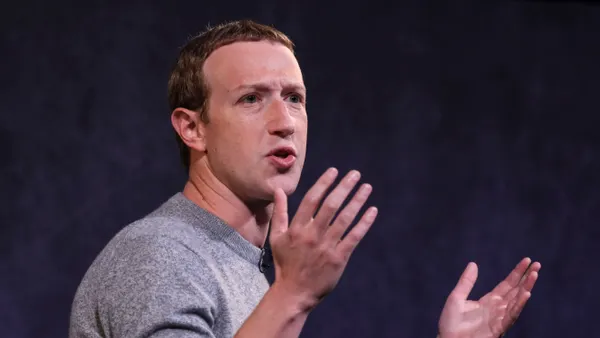 Meta Platforms CEO Mark Zuckerberg, wearing a gray sweater, puts his hands up during a presentation.