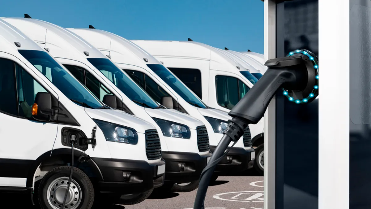 Electric vehicles charging station on a background of a row of vans