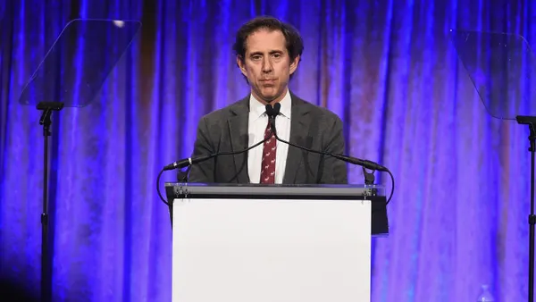 A person speaking at a podium.