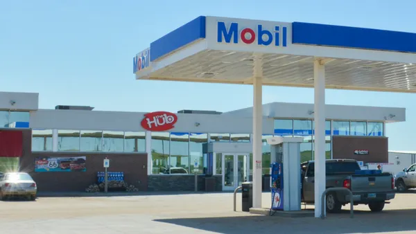 A photo of the exterior of a convenience store and gas station. A sign on the building says The Hub while the fuel canopy says Mobil.