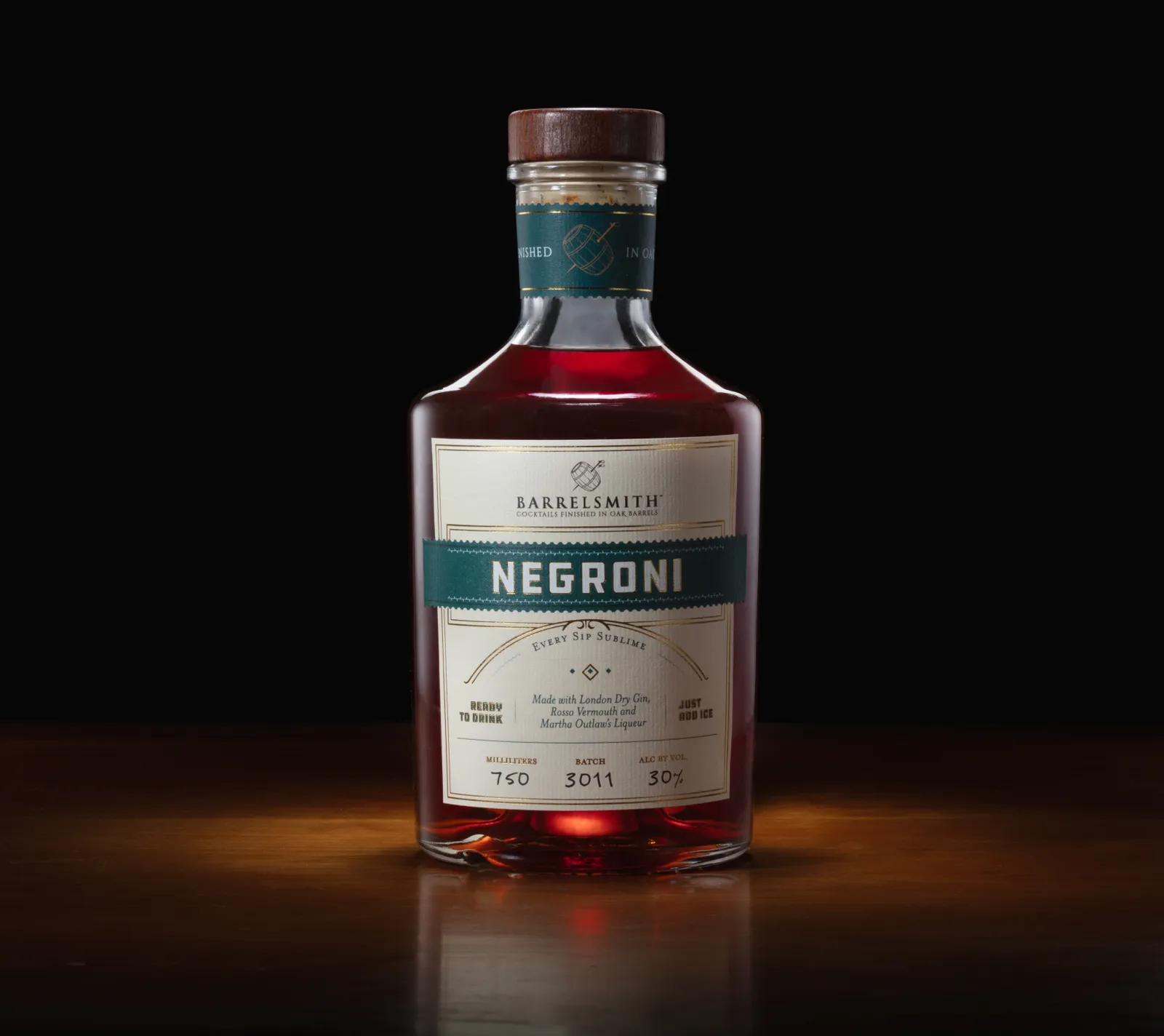 A short, glass bottle that contains a Negroni cocktail