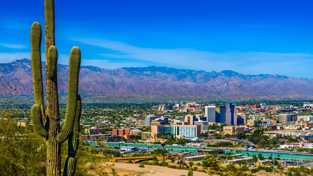 Tucson Arizona skyline cityscape panorama framed by saguaro cactus, mountains - stock photo