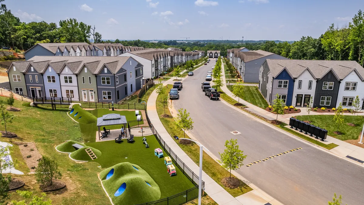 Overhead view of rows of new homes with a street between.