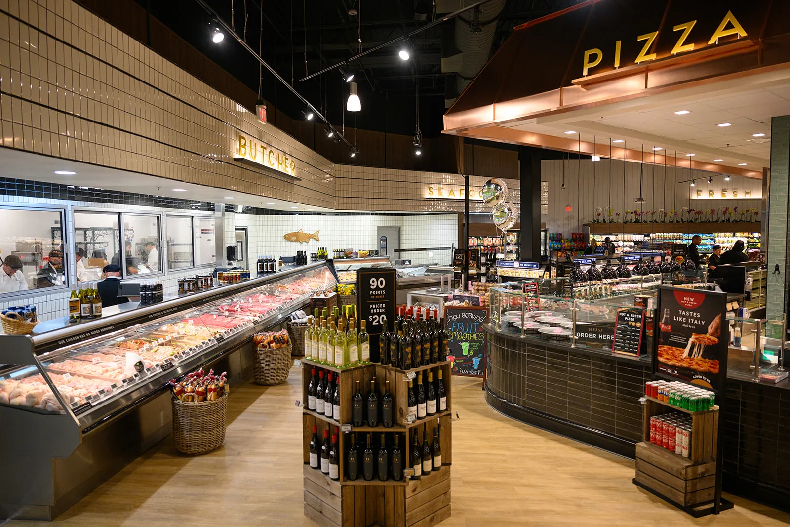 Inside a Fresh Market store in Jensen Beach, Florida, showing a butcher counter and pizza counter