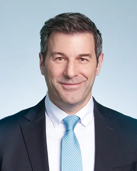 Headshot of a man with grey hair in a suit.