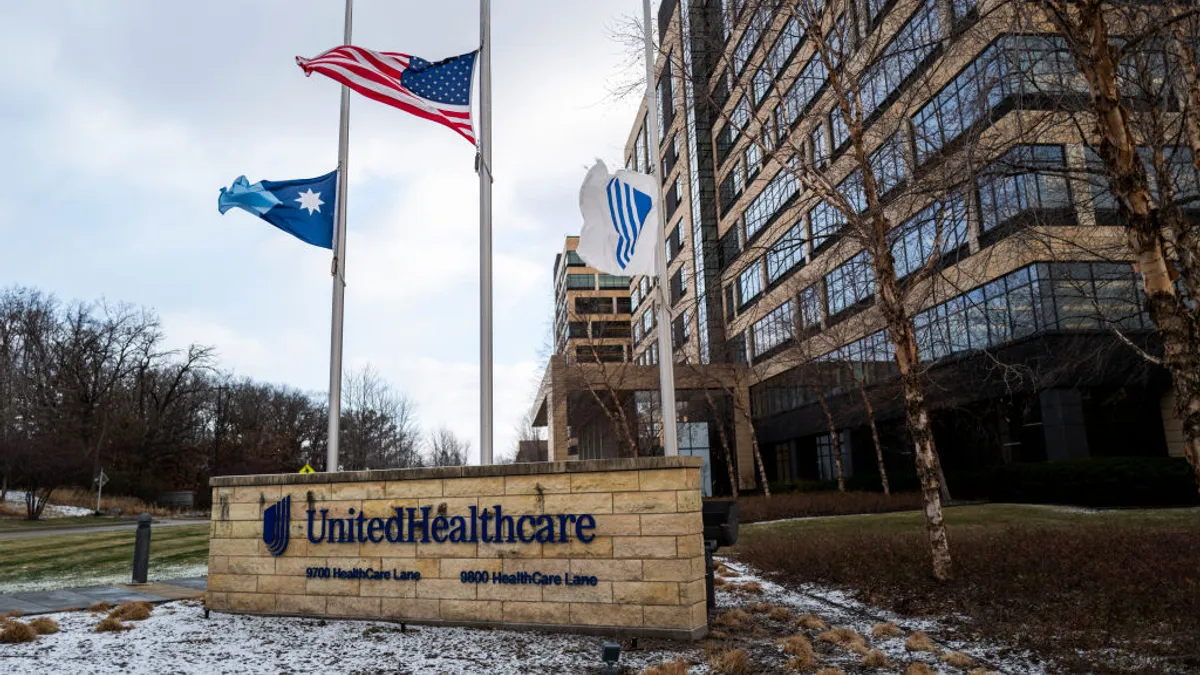 Three flags fly at half mast outside UnitedHealthcare's corporate headquarters in Minnetonka, Minnesota.