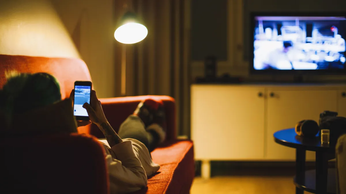 Young woman relaxing with smartphone on sofa