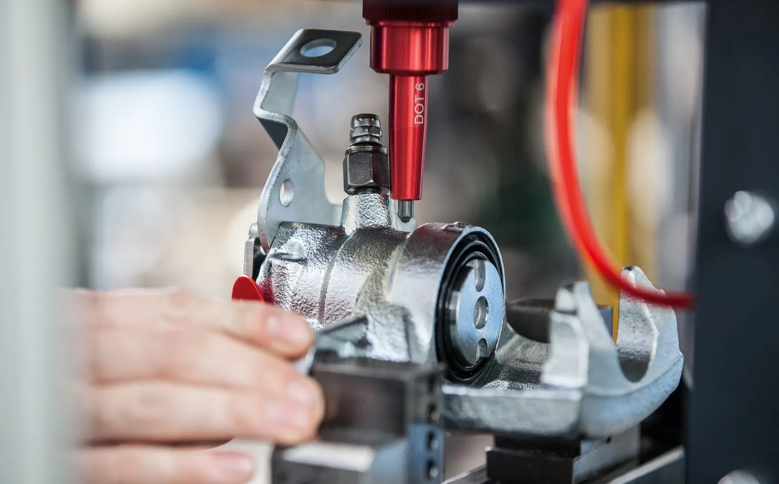 A hand and tools at the remanufacturing of a automotive brake caliper assembly