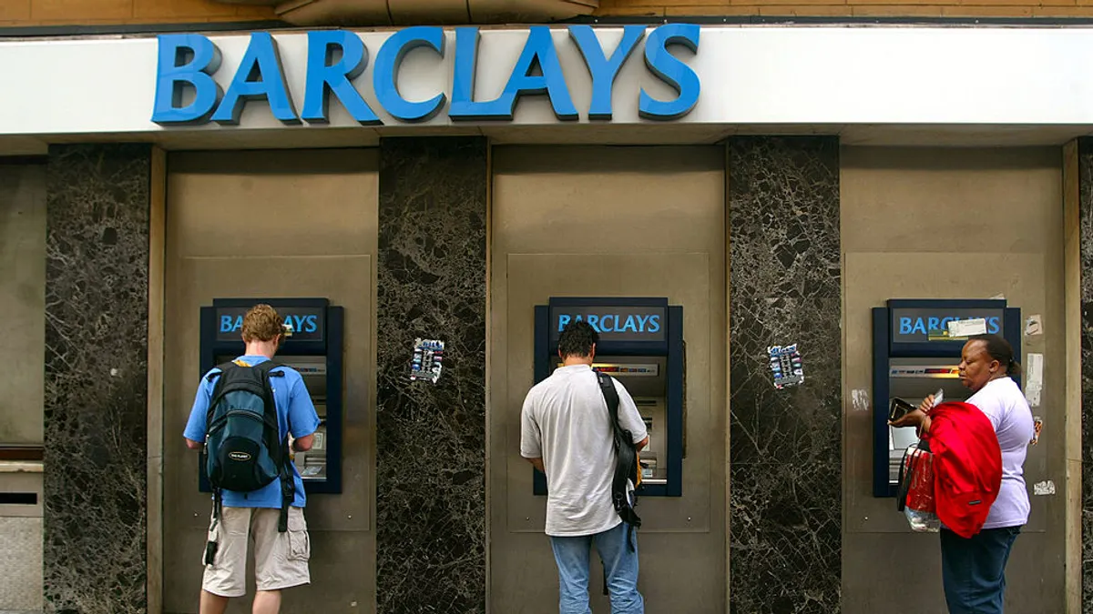 People seen using an ATMs at a Barclays bank.