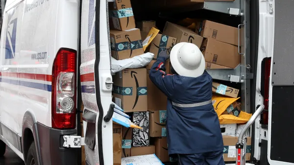 A U.S. Postal Service worker unpacks packages from a truck on December 02, 2019 in San Francisco, California.