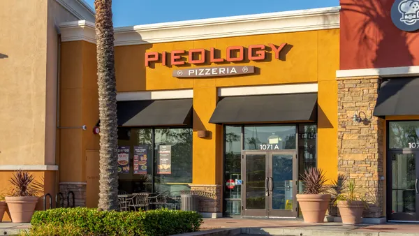 An image of a storefront with a sign that says Pieology Pizzeria.