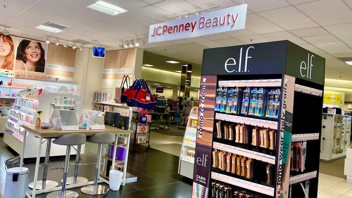 A space within a department store with beauty product displays, with an overhead sign reading "JC Penney Beauty."