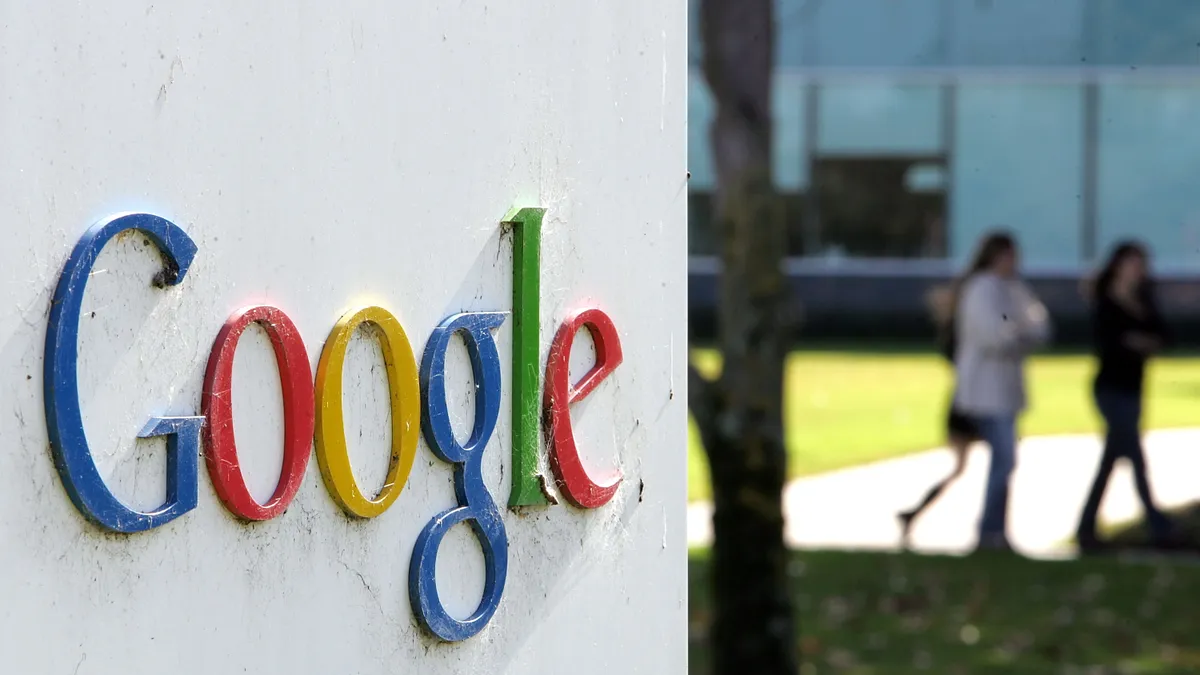 People walk near a sign outside of Google headquarters January 31, 2007 in Mountain View, California.