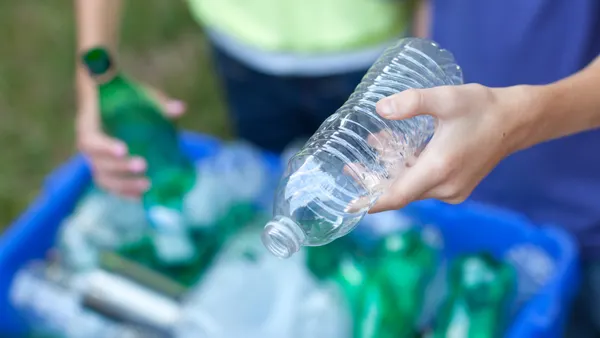 People placing bottles in recycling bin