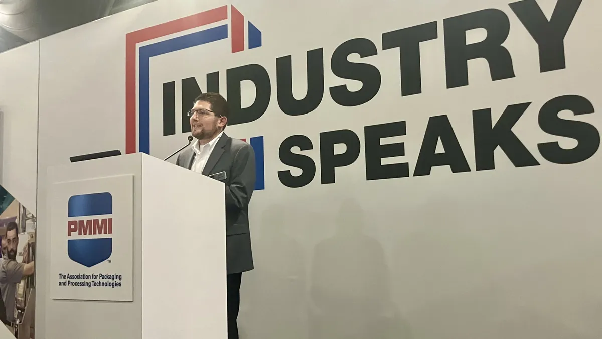 Andy Lomasky, senior director of IT for PMMI, stands at a PMMI podium on the Industry Speaks stage at Pack Expo East on March 20, 2024.