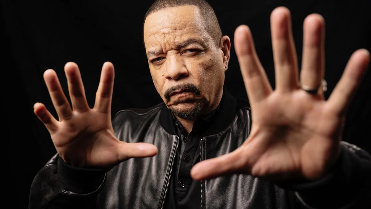 Actor Ice T puts hands up in the air.