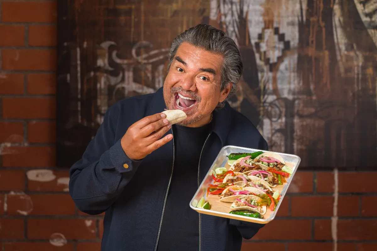 George Lopez posing with his Tacos